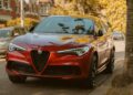 A red alfa romeo suv is parked on the street.