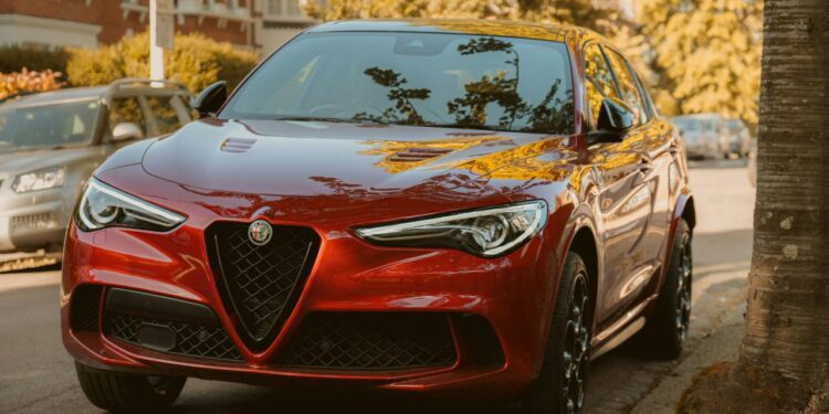 A red alfa romeo suv is parked on the street.
